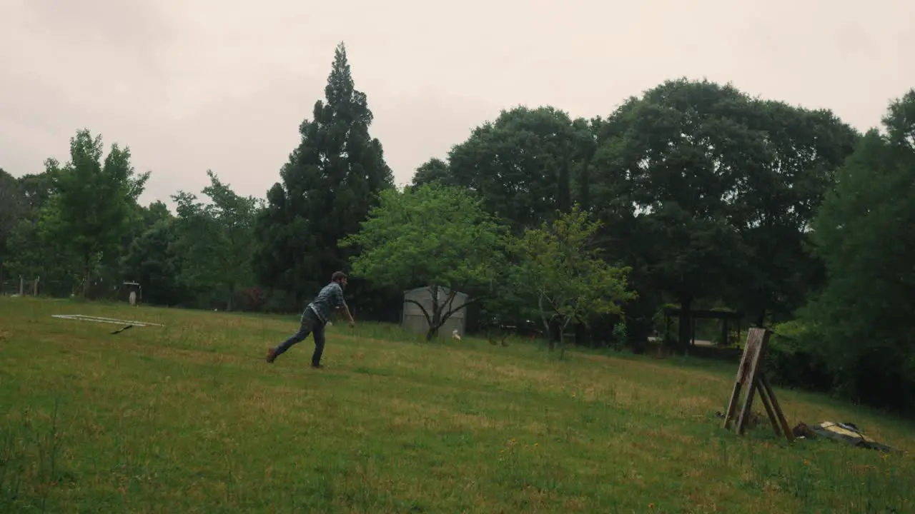 Male training for Axe throwing competition in green natural park throwing ax at a target