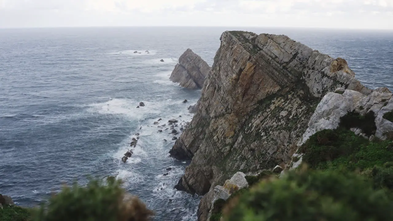 Scenic seascape in Cabo Peñas cliffs in Asturias Spain ocean water crashing against rock formations beach coastline