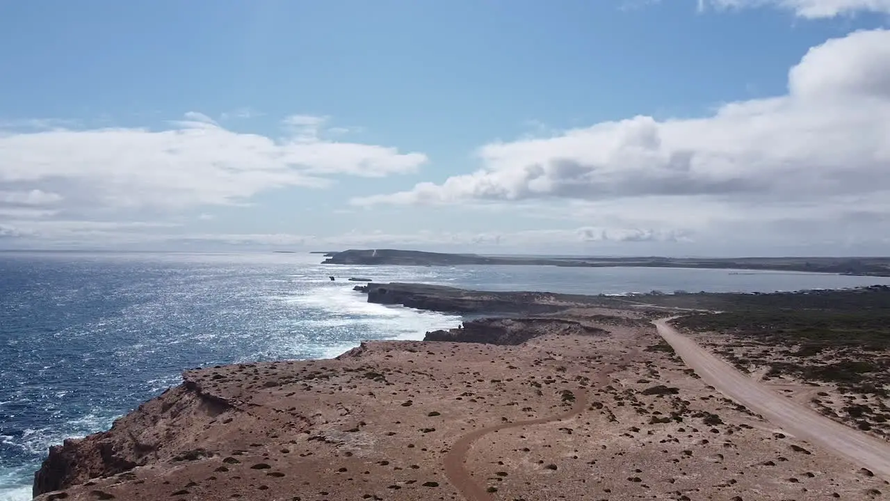 Empty coastal expanse bordered by rugged cliffs