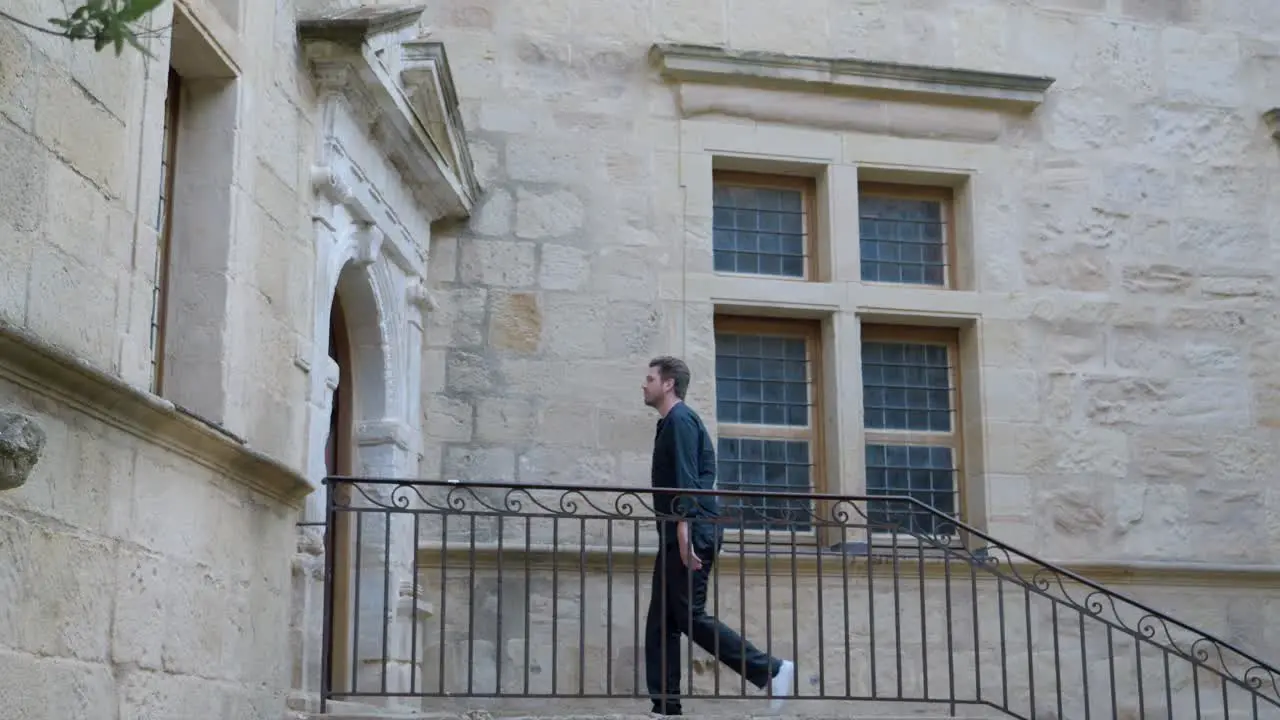 Man walking up the stairs of an old stone building