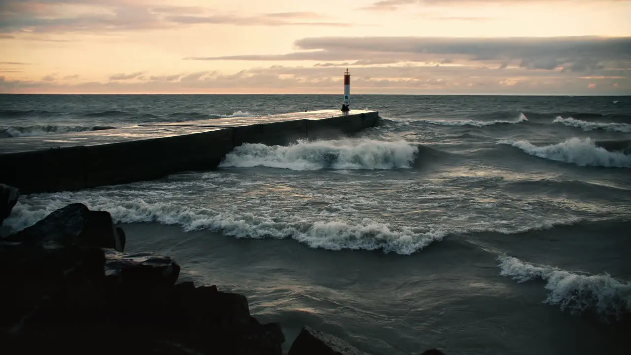 Powerful Storm Waves Crashing against Coastal Shoreline Lighthouse Pier