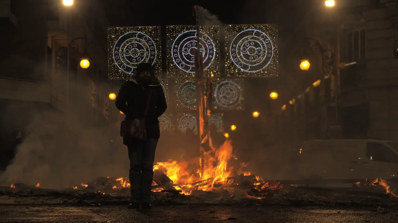 A female figure standing next to the dying bonfire on the Falles night