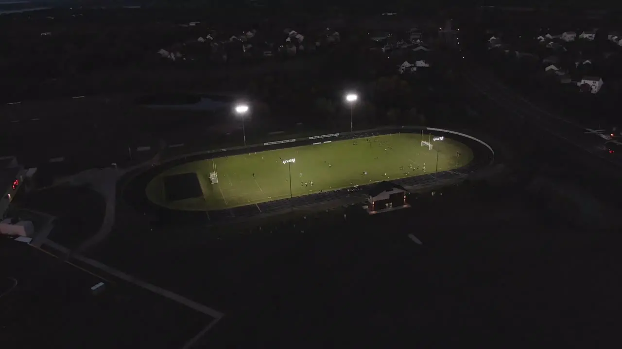 Aerial footage of a football field stadium with lights on 4k drone