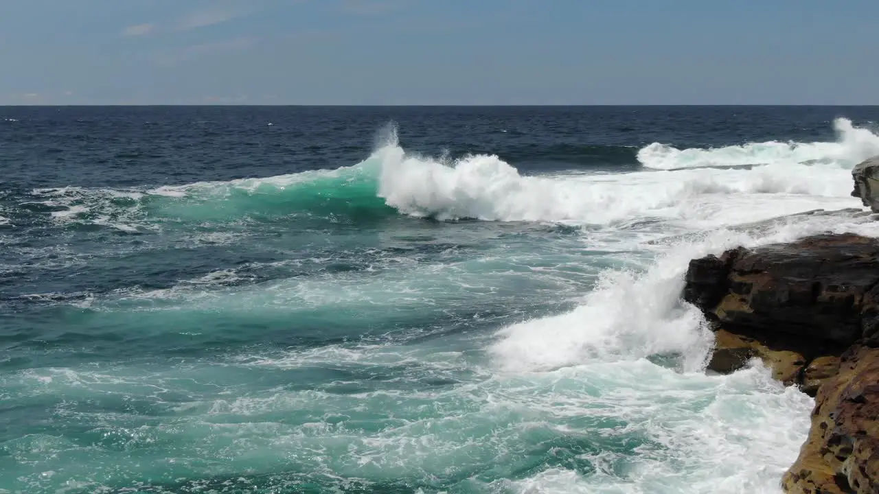 Waves breaking on rocky cliff near Bondi Beach Australia