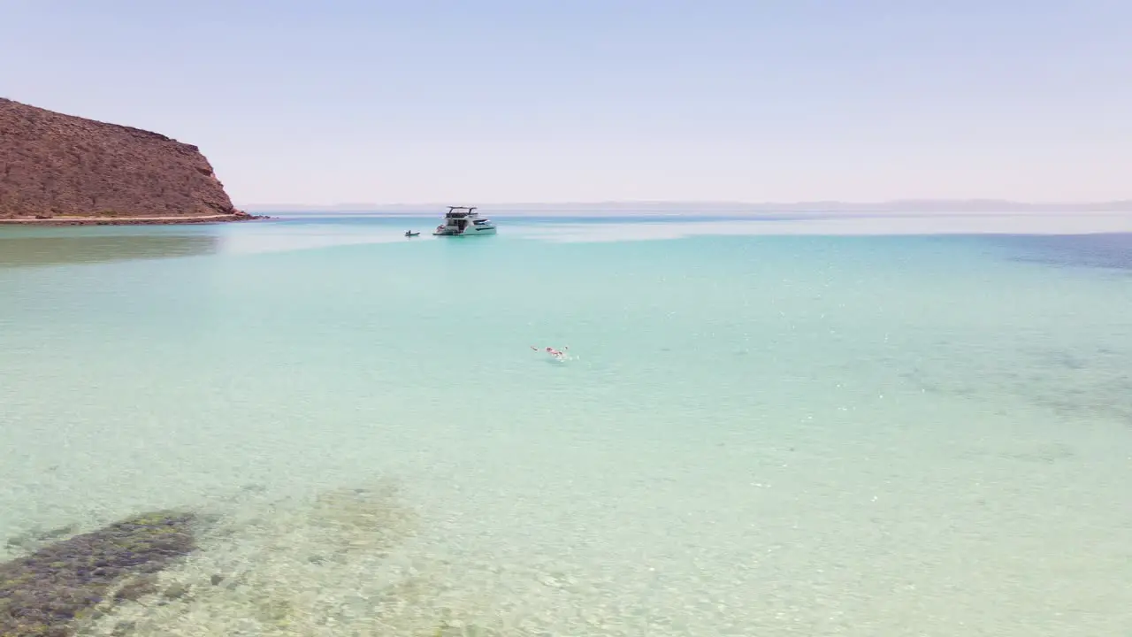 Aerial holidaymaker swimming in turquoise sea near luxury yacht tropical bay of Balandra Beach