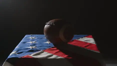 Low Key Lighting Studio Shot Of American Football On Stars And Stripes Flag 2