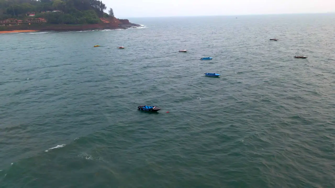 goa Sinquerim Candolim Beach drone bird's eye view boats floating over seawater beach in goa drone orbital shot