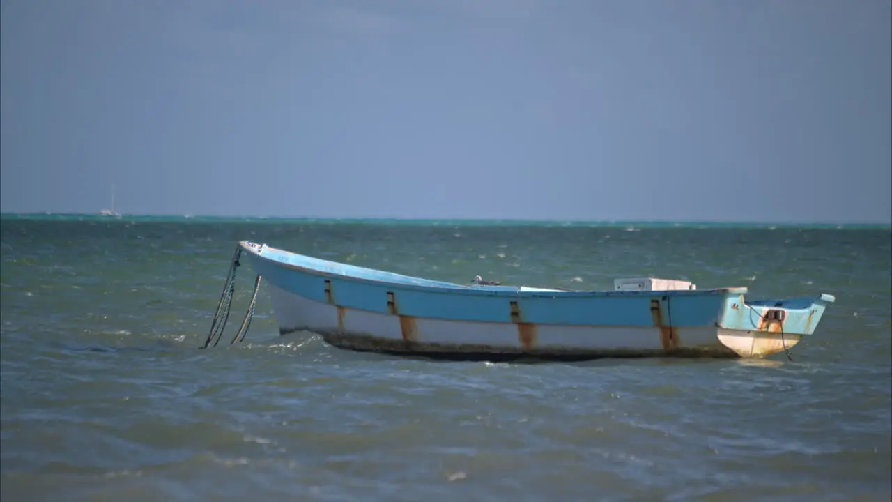 Slow motion of an old rusty vessel floating on the calm waters of the caribbean sea in Cancun Mexico