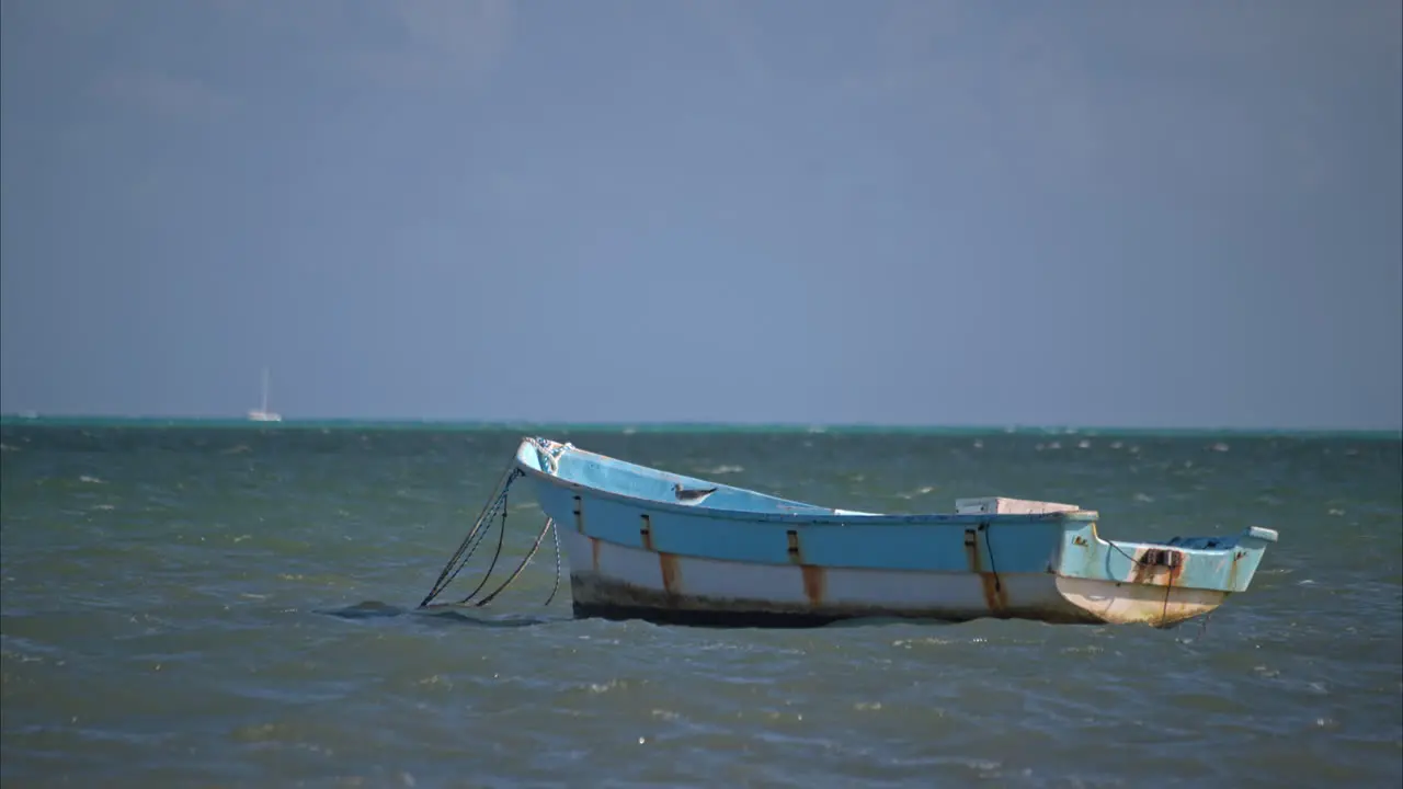 Slow motion of an old rusty boat bloating with the rhythm of the waves in a tranquil day at the sea