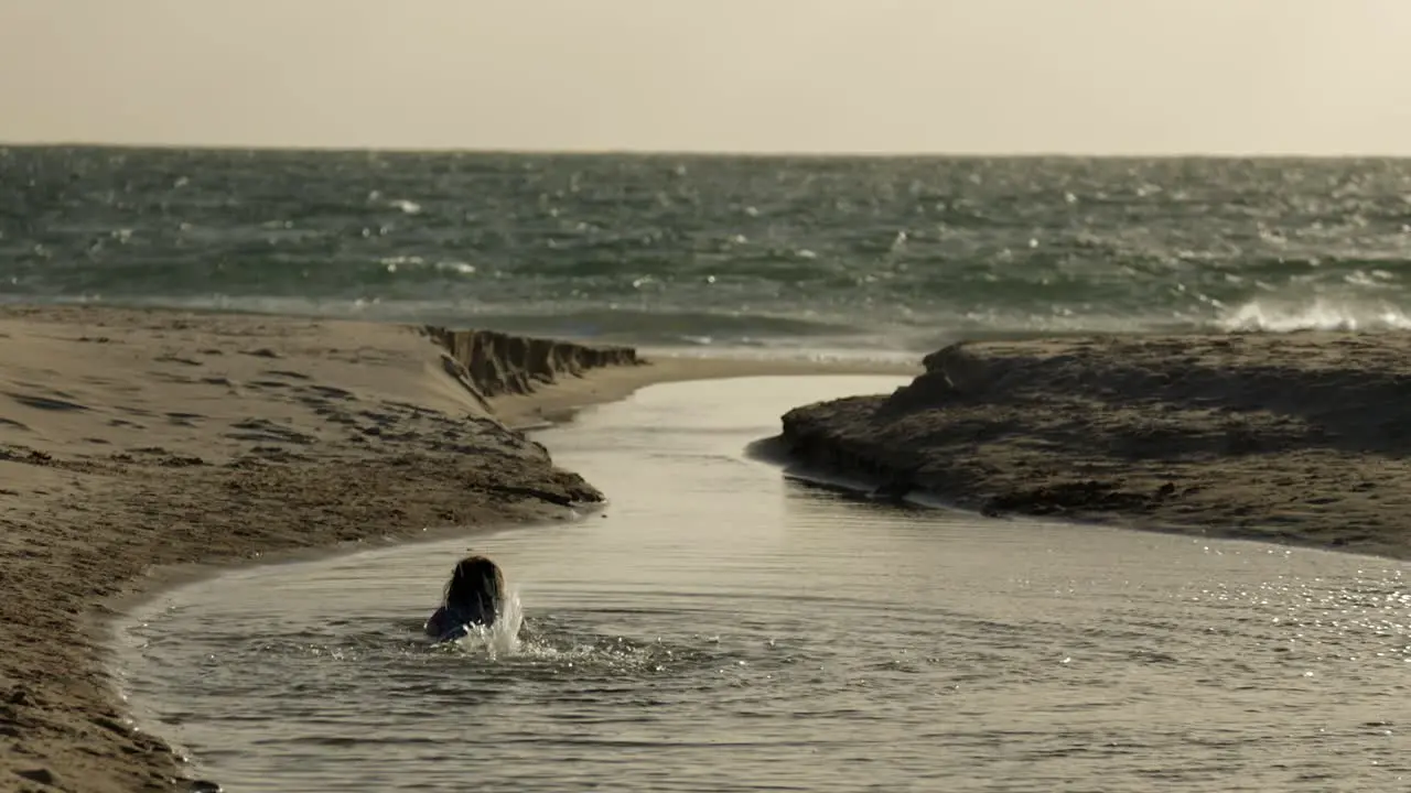 Girl Child Swimming Playing Beach In The Ocean Lake Water Long Shot