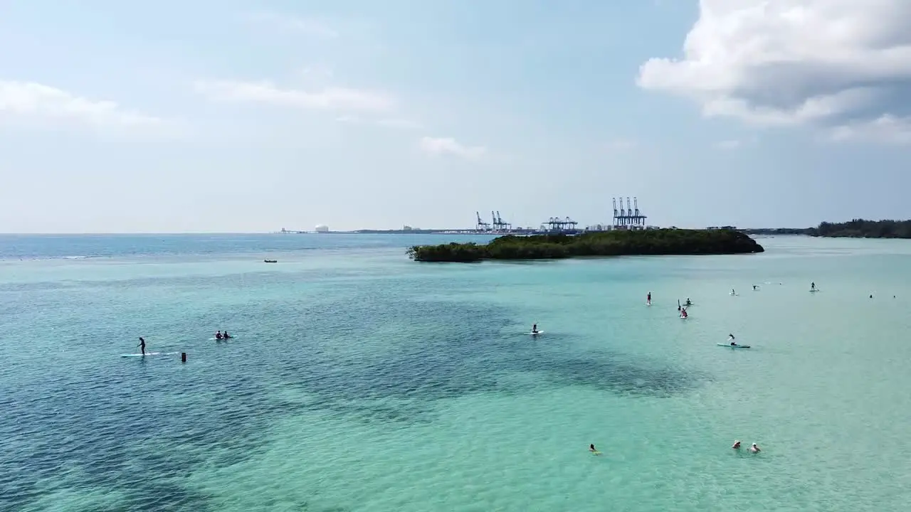 Drone shot capturing group of tourists paddle surfing on beautiful day in boca chica