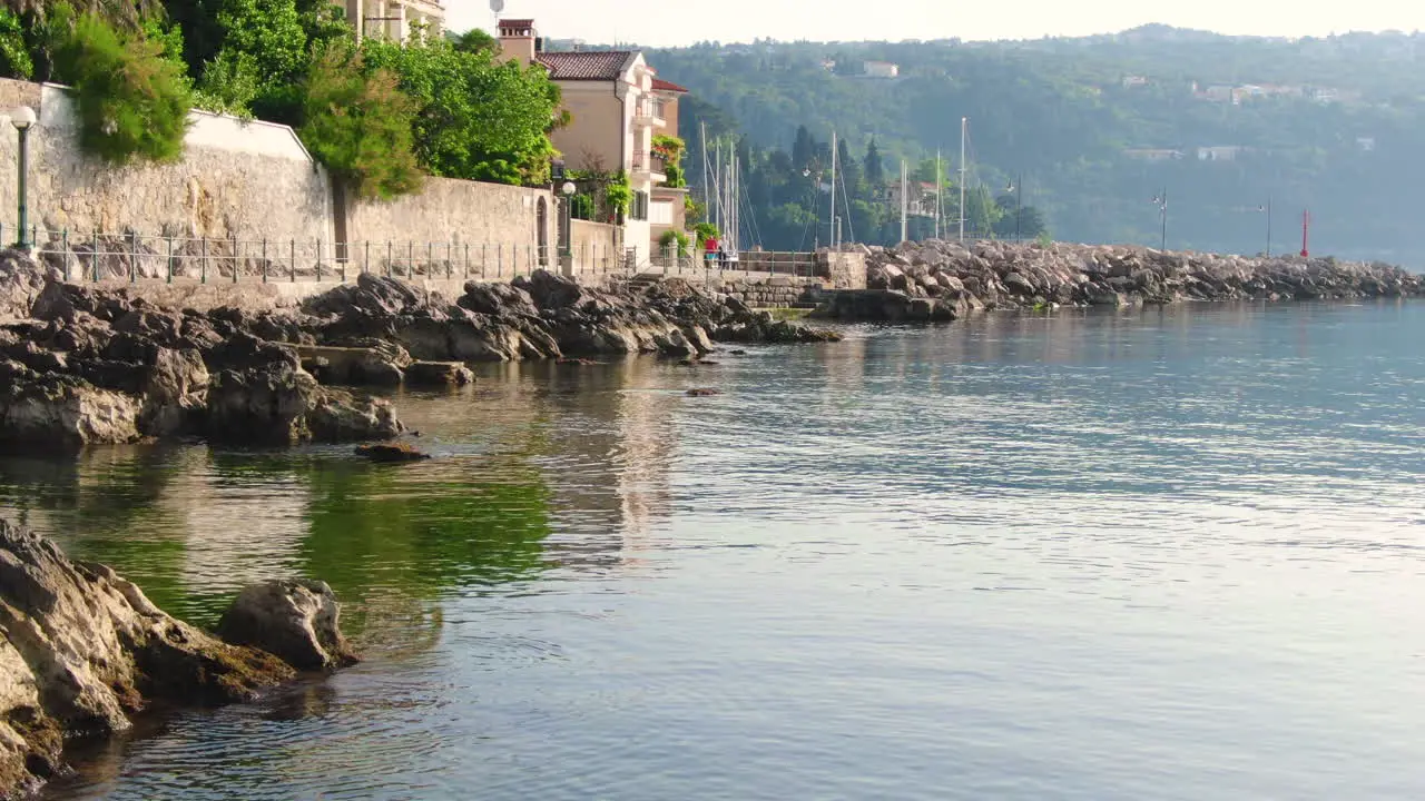 Long rocky coast and the city walls on the coast with walking path by the sea