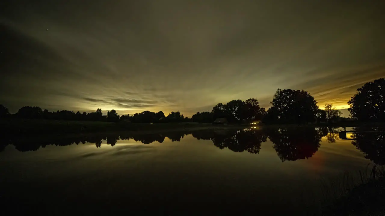 Dramatic time-lapse of starry milky way night sky changing colors and reflection on water