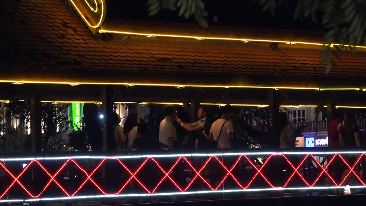 Tourists Walking on an Illuminated Bridge