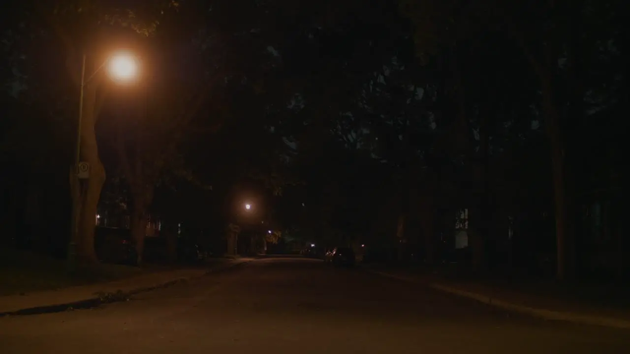 Dark Lit Empty Road In Montreal With With Car Going Past In The Distant