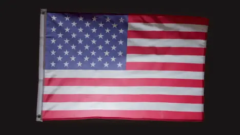 Studio Shot Of Flag Of America Flying Against Black Background