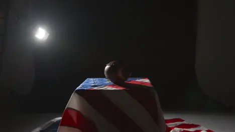 Low Key Lighting Studio Shot Of American Football On Stars And Stripes Flag 6