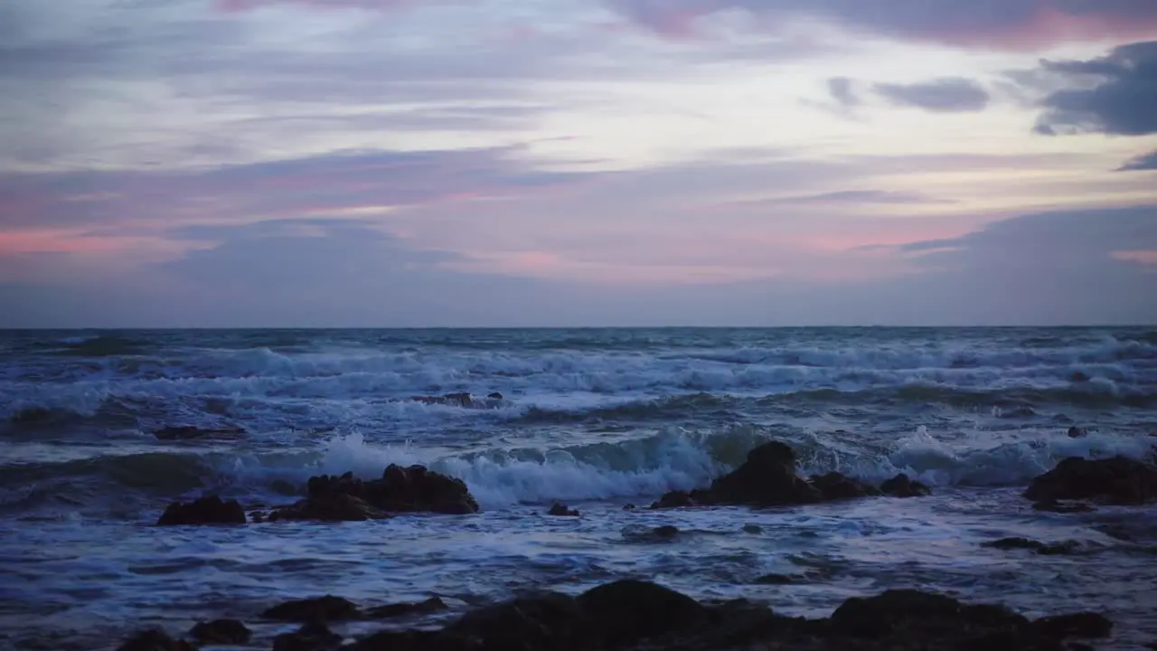 Ocean waves at the rocks with colourful sky