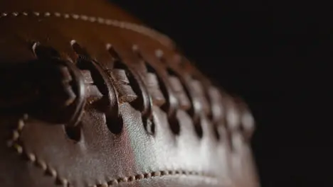 Defocused Close Up Studio Shot Of Person Picking Up American Football 