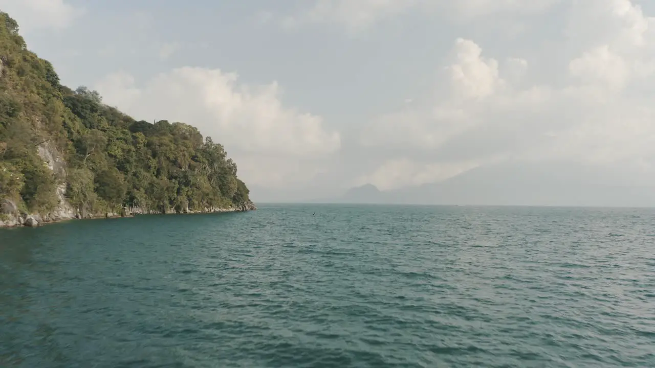 Drone aerial flying close to lake Atitlan towards a man on a boat in Guatemala