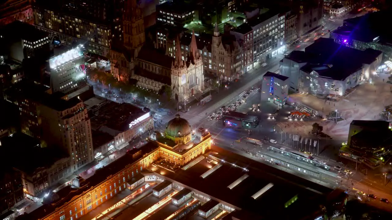 Night timelapse with of Flinders Station Paul Cathedral and Federation Square of Melbourne City filled with movements from pedestrians traffics and trams from Eureka Tower on loop