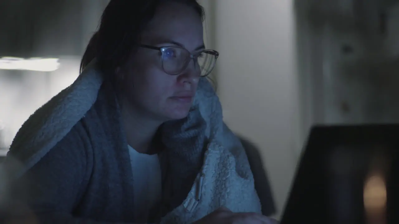 Late Night Emailing freezing woman Wrapped in a warm Blanket