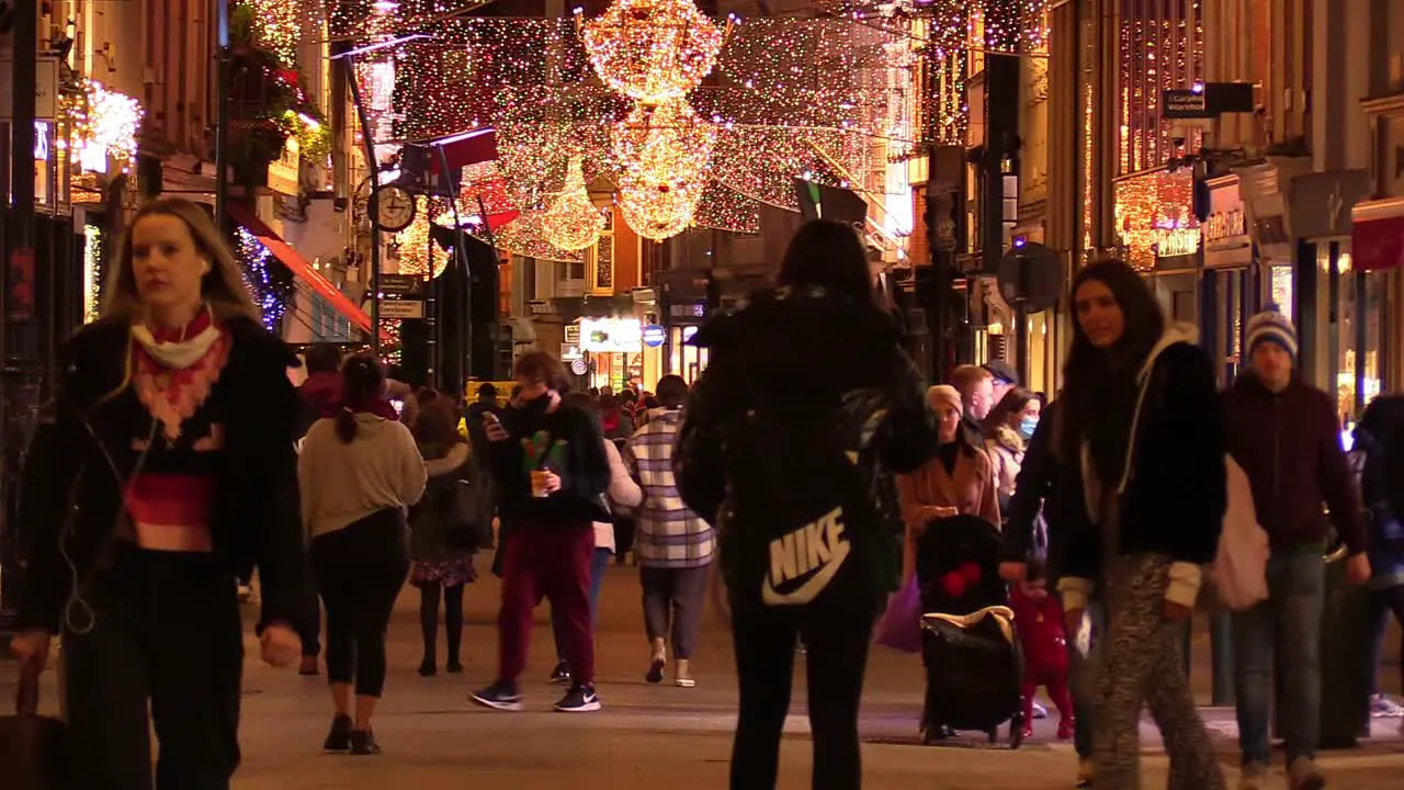 Still shot of a Dublin street at Chrismas time in hard times with some people on a not so busy street and local businesses closed