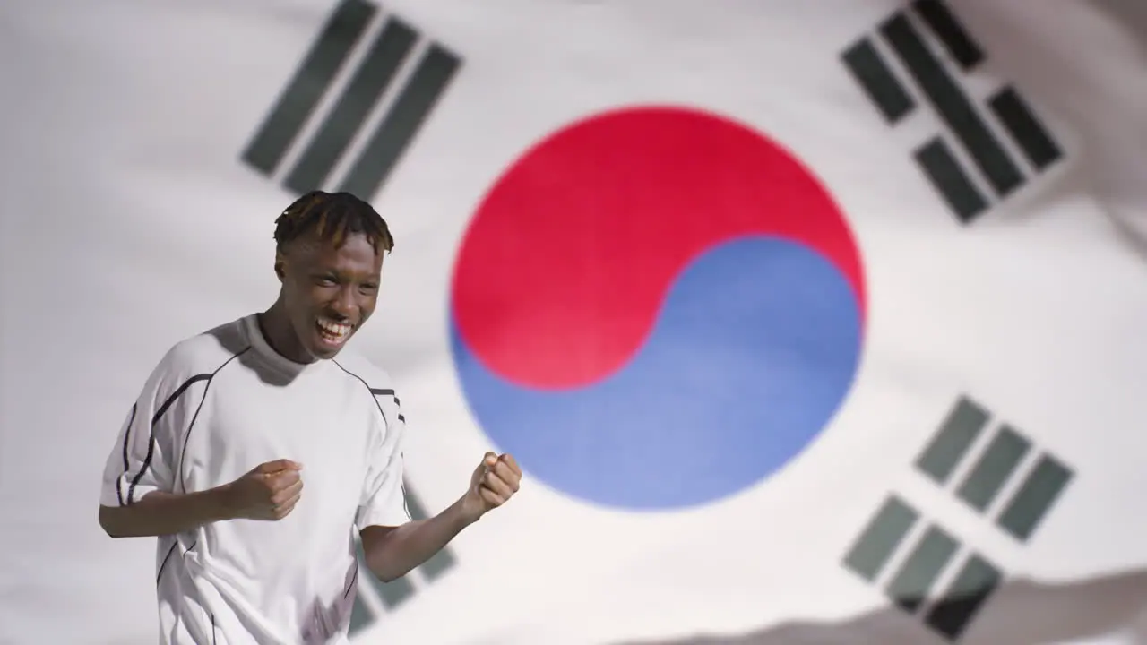 Young Footballer Celebrating to Camera In Front of South Korea Flag 02