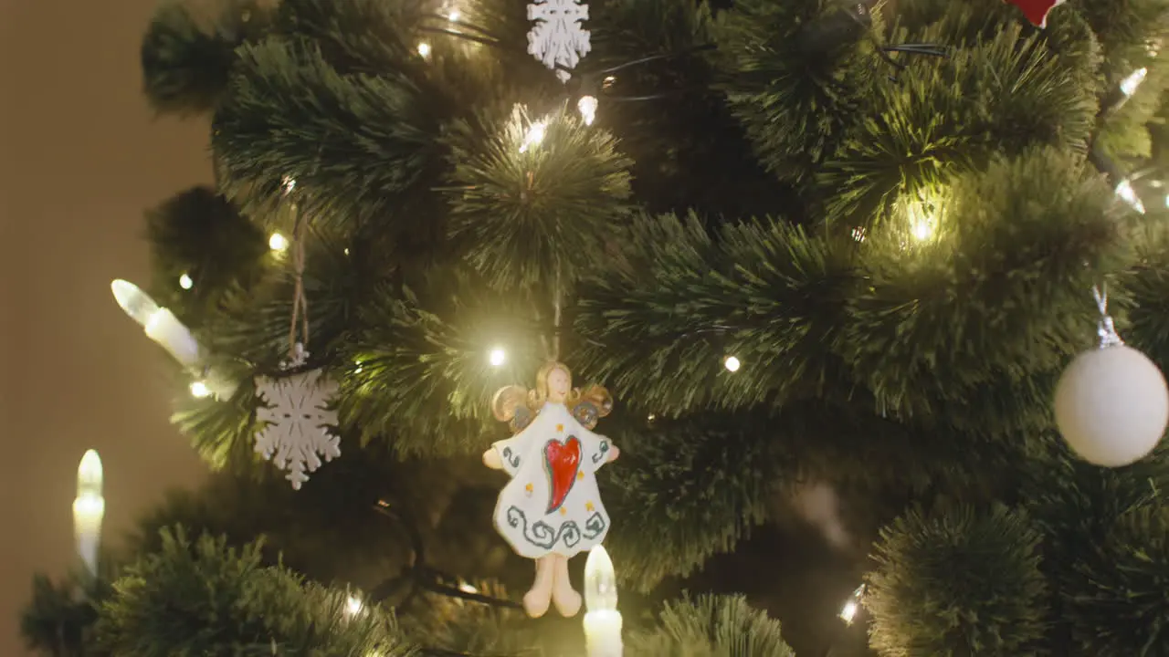 La Cámara Se Enfoca En El ángel Colgado En El árbol De Navidad Con Luces