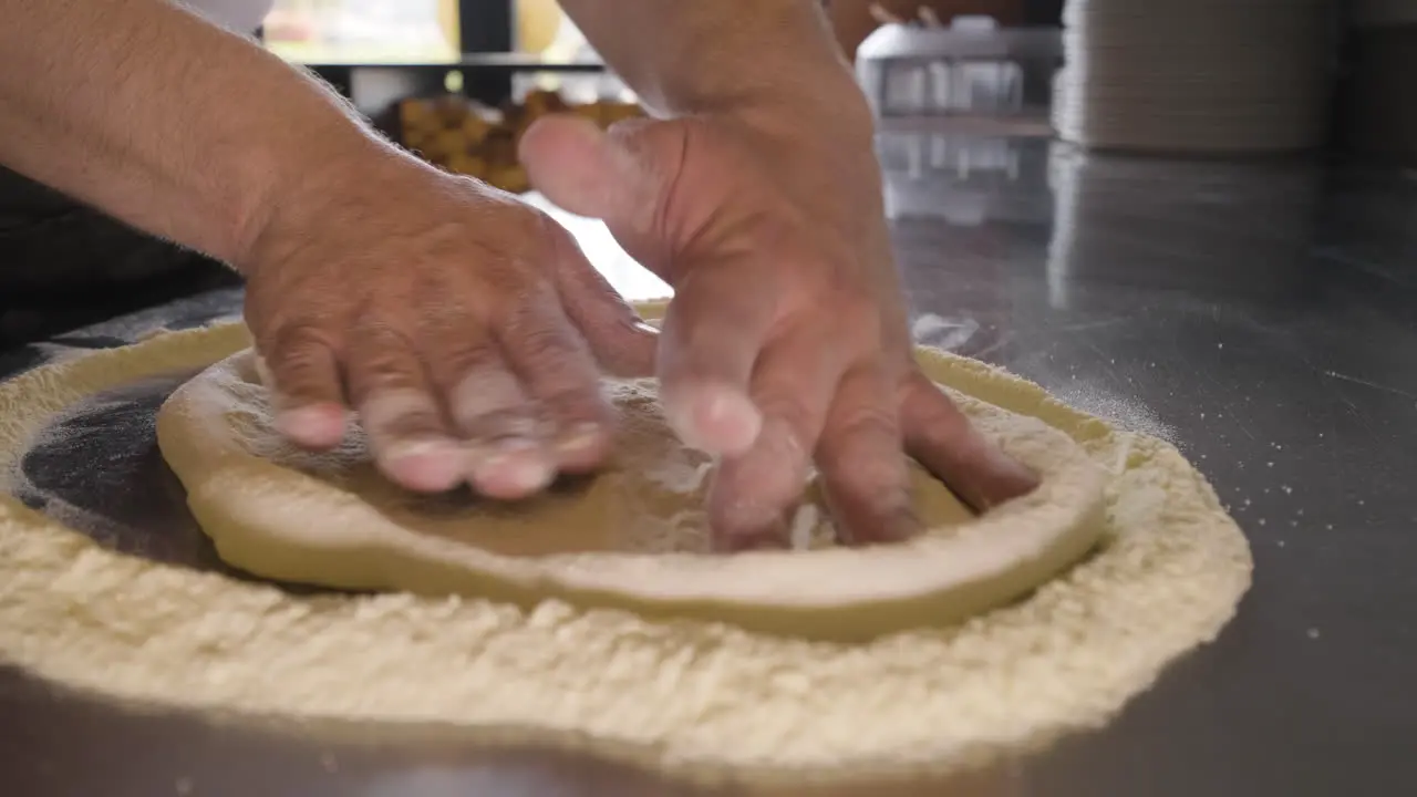 Nahaufnahme Eines Küchenchefs Der Pizzateig Auf Einer Arbeitsplatte In Der Küche Eines Restaurants Knetet 1