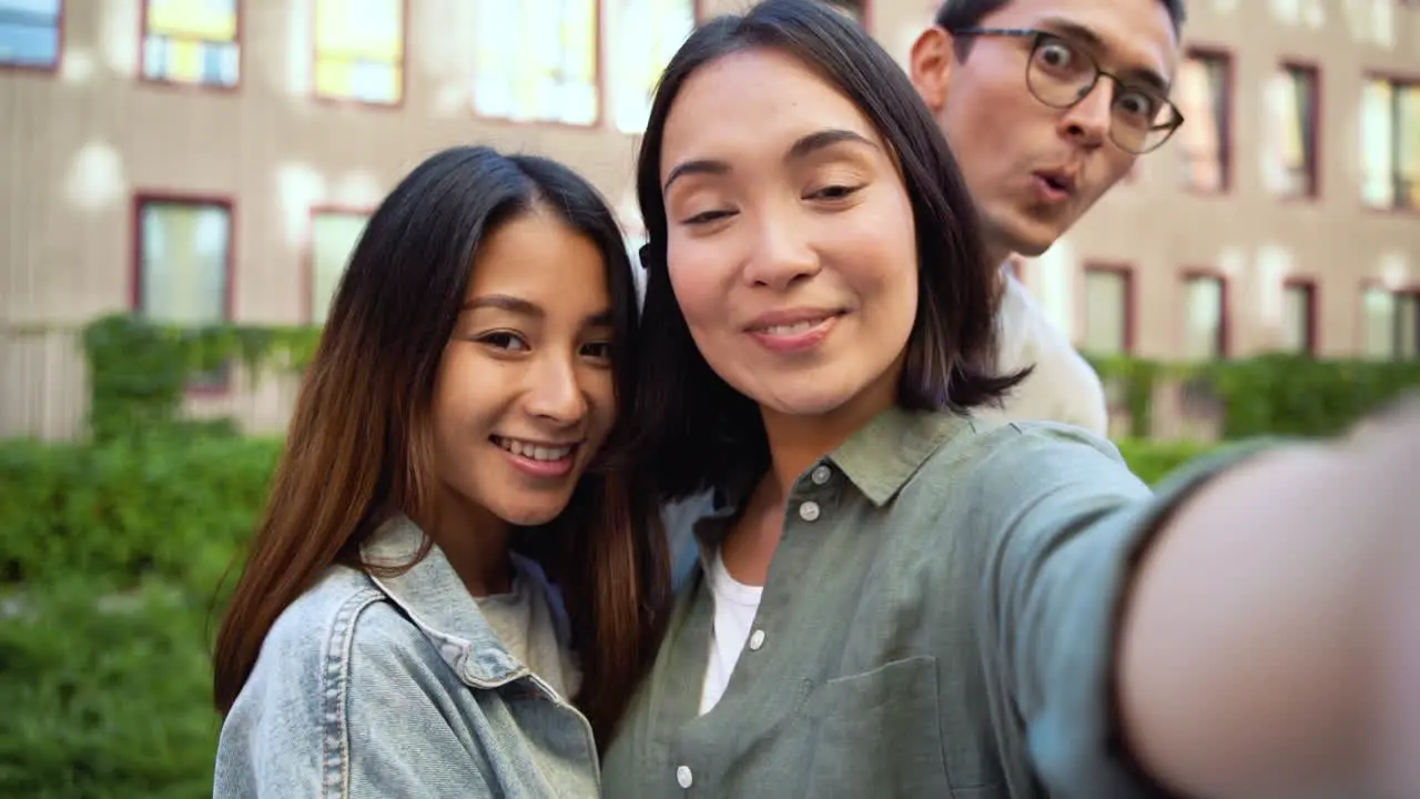 Grupo De Tres Jóvenes Amigos Japoneses Mirando La Cámara Y Tomando Fotos Selfie Juntos