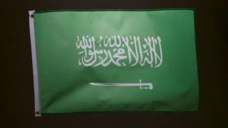 Studio Shot Of Flag Of Saudi Arabia Flying Against Black Background