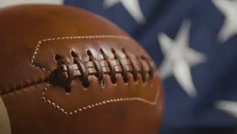 Focus Pulls From Close Up Shot Of Stars And Stripes Flag To American Football 