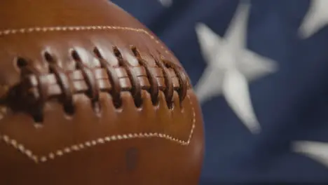 Focus Pulls From Close Up Shot Of American Football To Stars And Stripes Flag 2