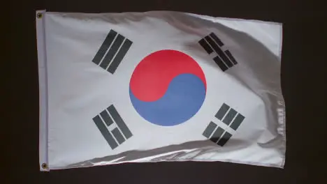 Studio Shot Of Flag Of South Korea Flying Against Black Background