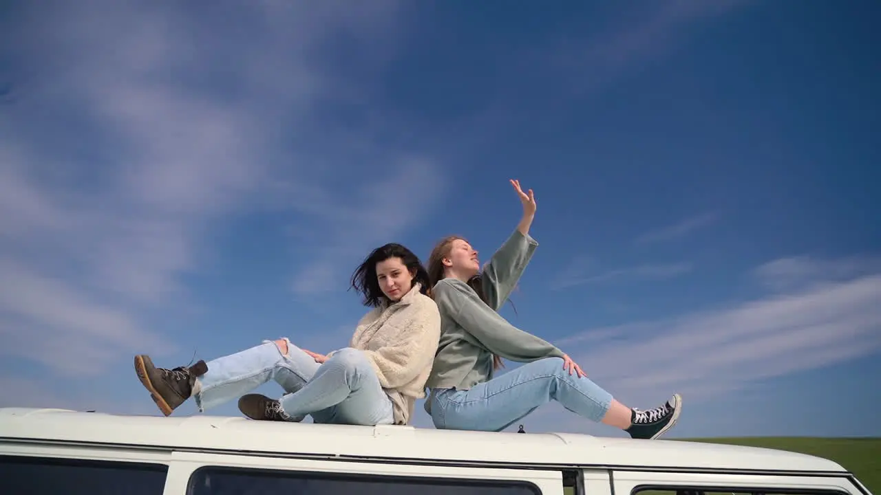 Two Young Girls On The Roof Of A Caravan In The Middle Of The Countryside