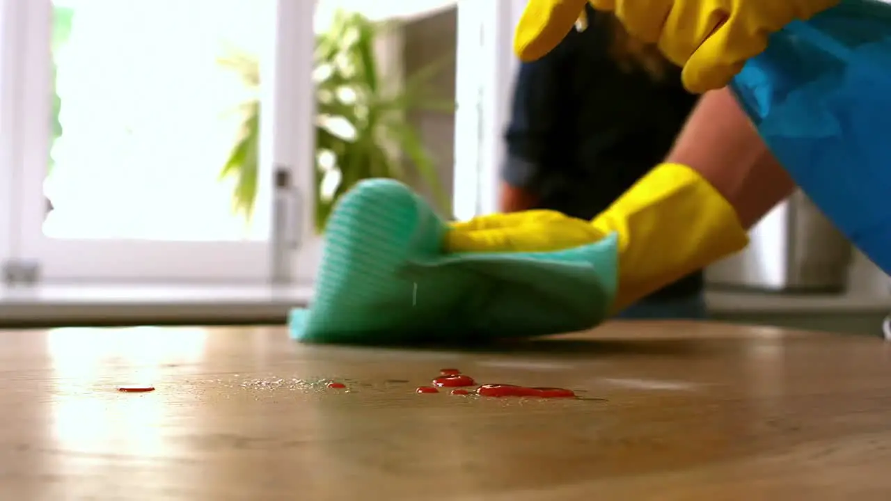 Handsome man cleaning table