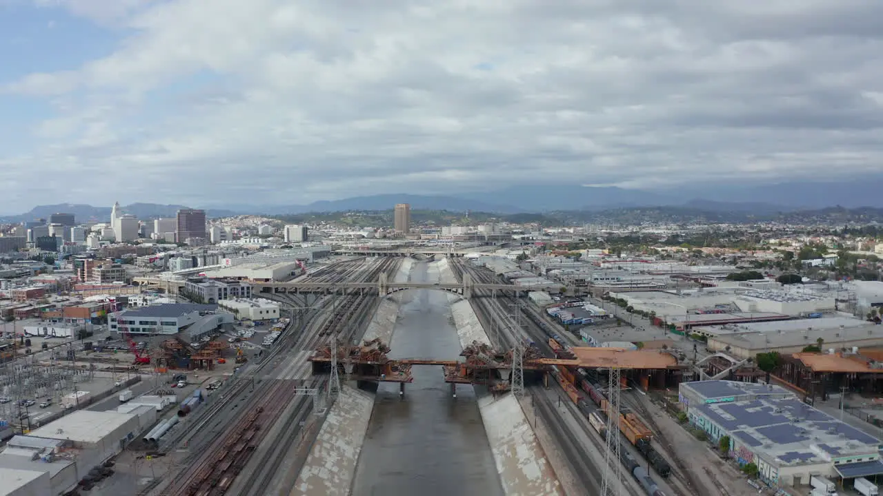 AERIAL View over Los Angeles River Bridge Being Built under Construction Site with Overcast Cloudy Sky