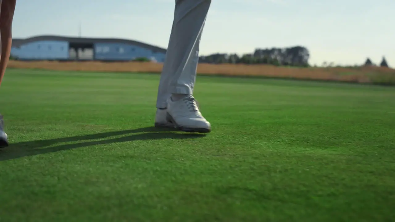 Golf couple legs going walk on course grass Two rich people stroll country club