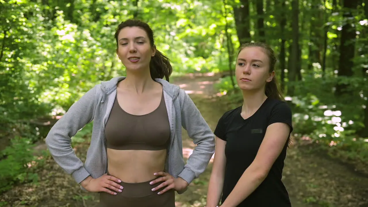 Two Pretty Girl Runners Warming Up And Start Running In The Woods