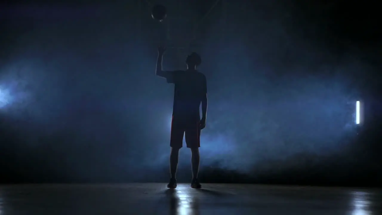 Silhouette of a basketball player throwing a ball