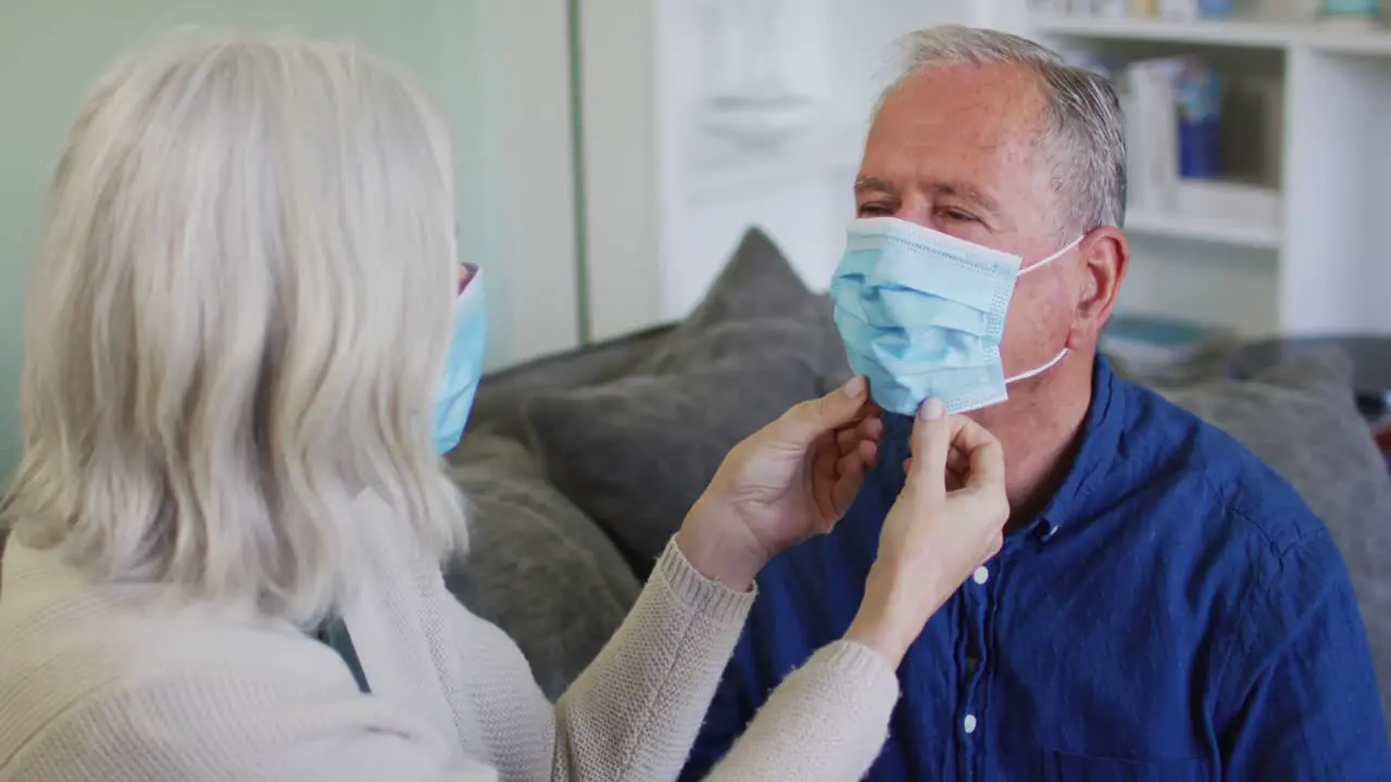 Senior caucasian couple wearing face masks at home