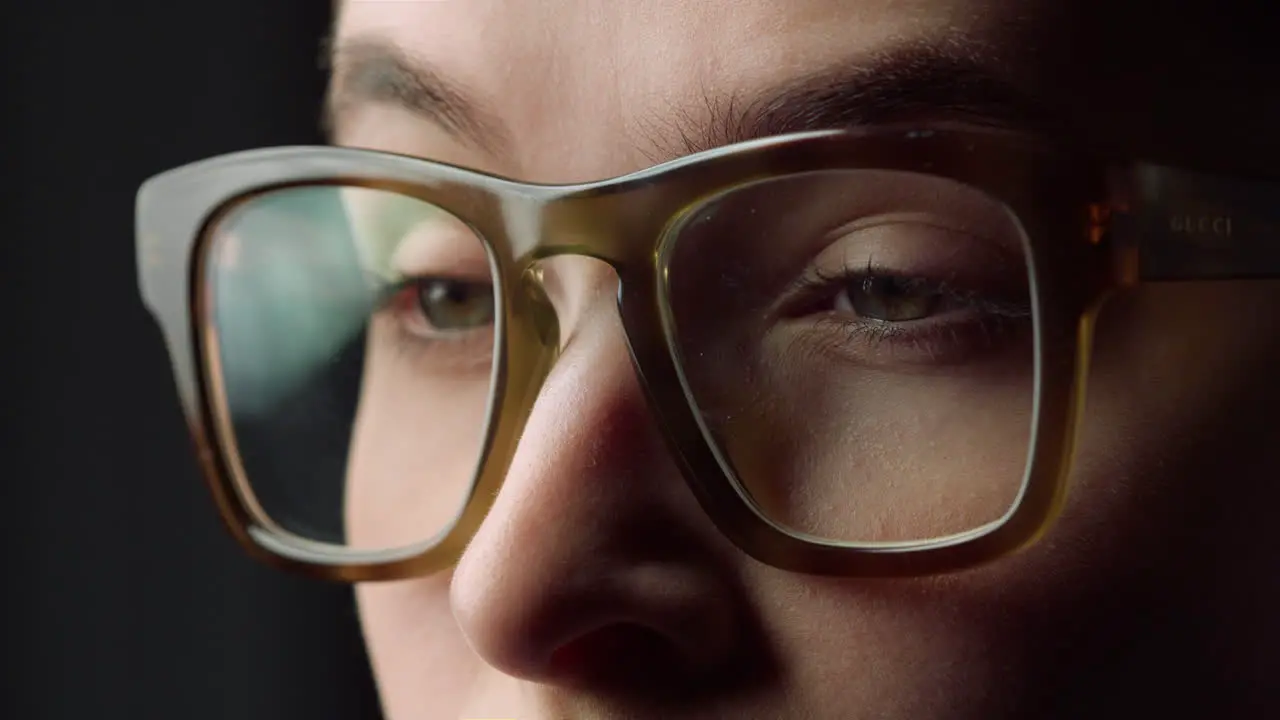 Macro face details of surprised business woman watching something in glasses