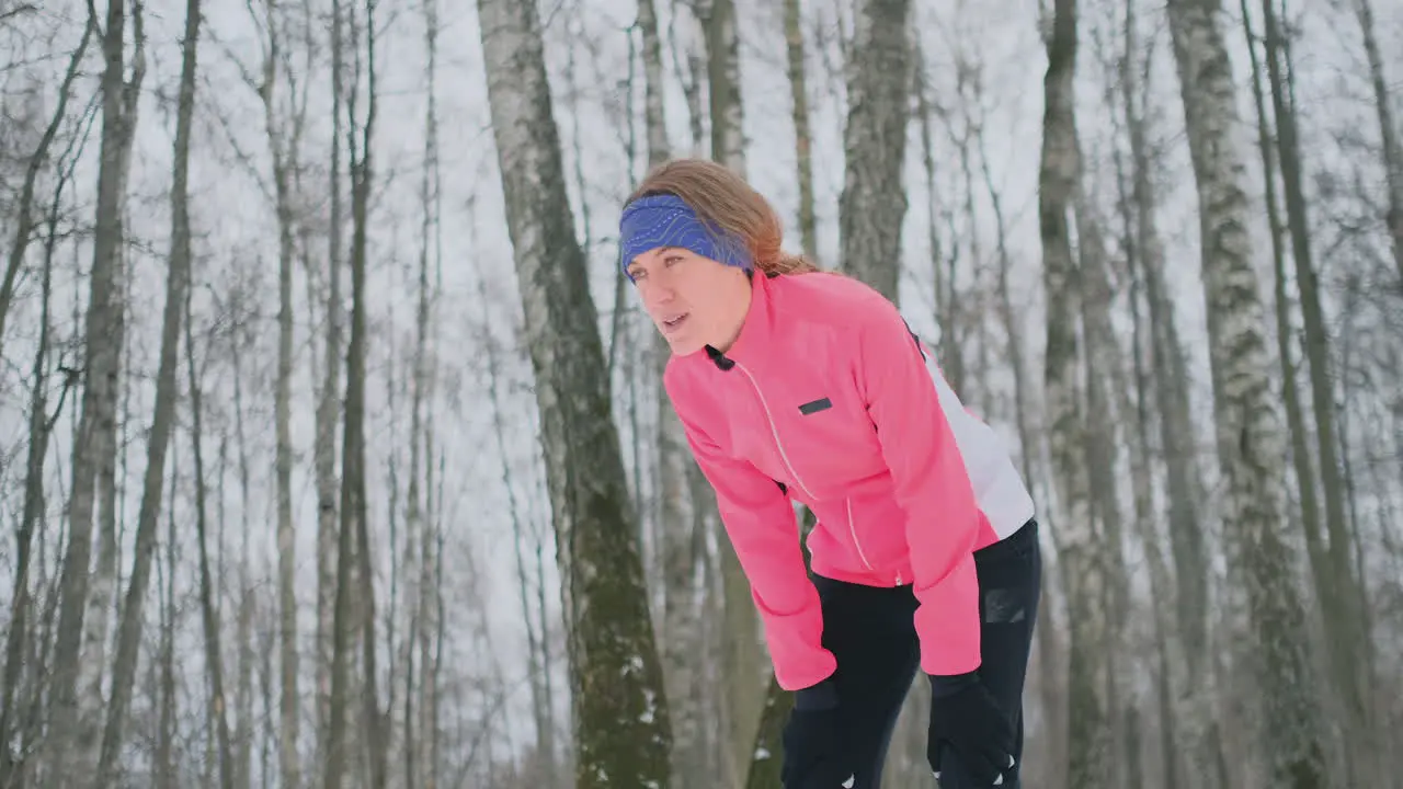 A young woman on a morning jog in the winter forest was tired and stopped to catch his breath He recovered his strength and overcame fatigue and continued to run Perseverance and overcoming weakness Push forward