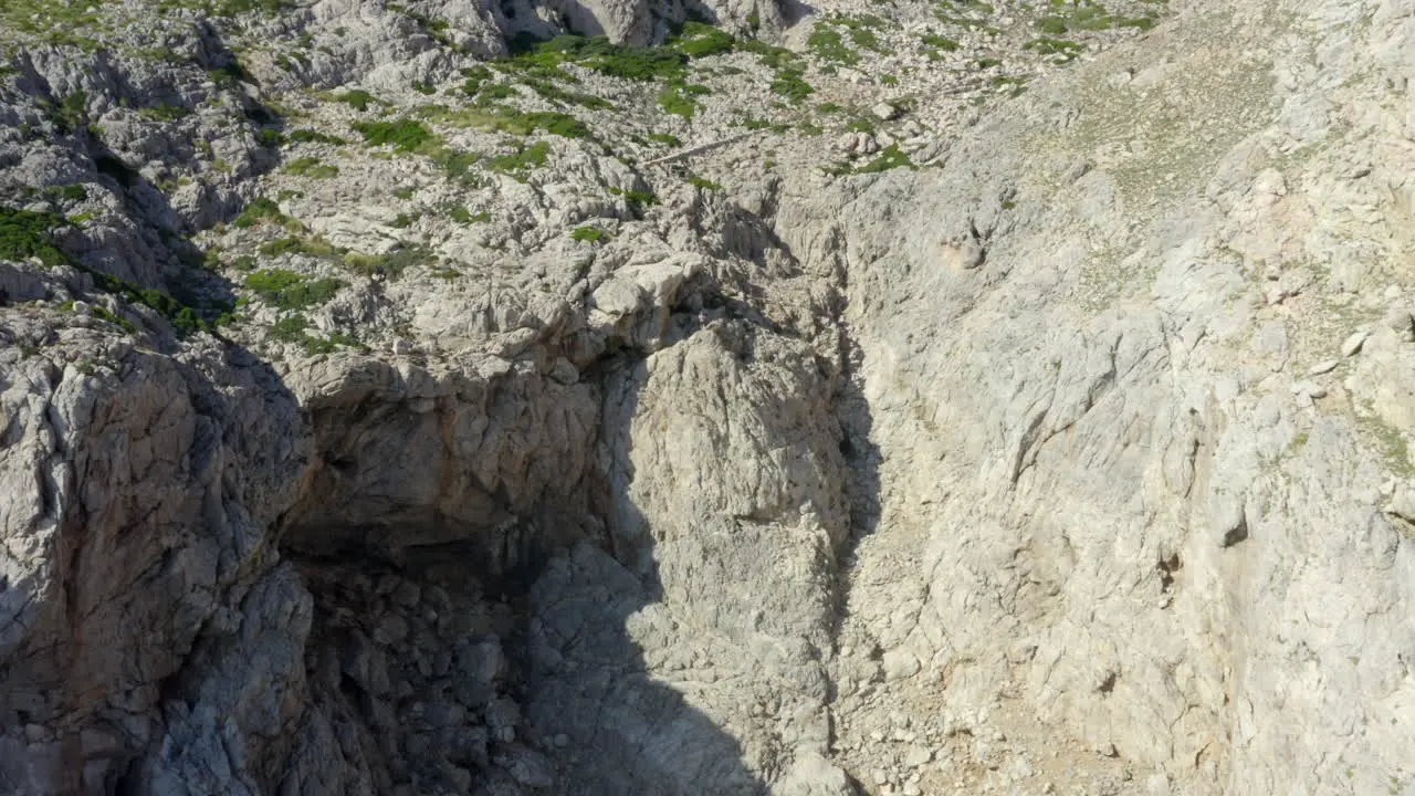 AERIAL Guy Standing on Edge of Cliff with Blue Water Waves crushing on Tropical Island Mallorca Spain Vacation Travel Sunny Waves