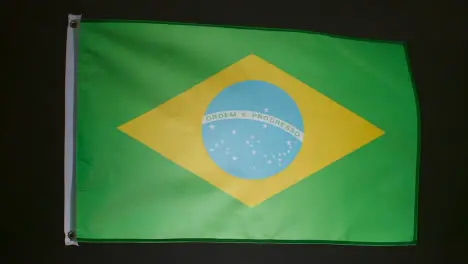 Studio Shot Of Flag Of Brazil Flying Against Black Background