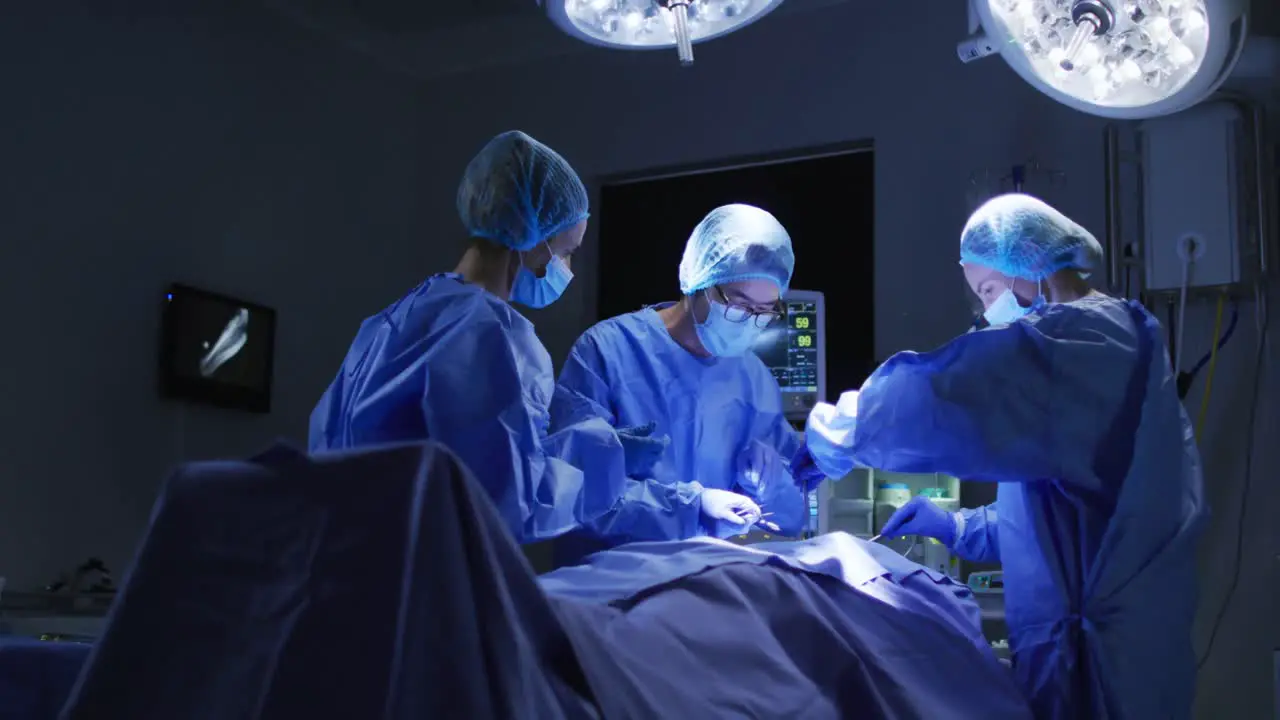 Diverse surgeons wearing surgical caps and face masks in operating theatre in hospital