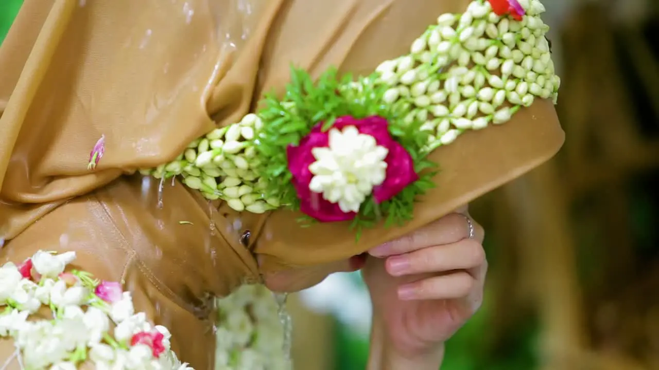 The bride are washed by their father and mother with running water from a jug during traditional Javanese or Sundanese splashes or Siraman before the wedding