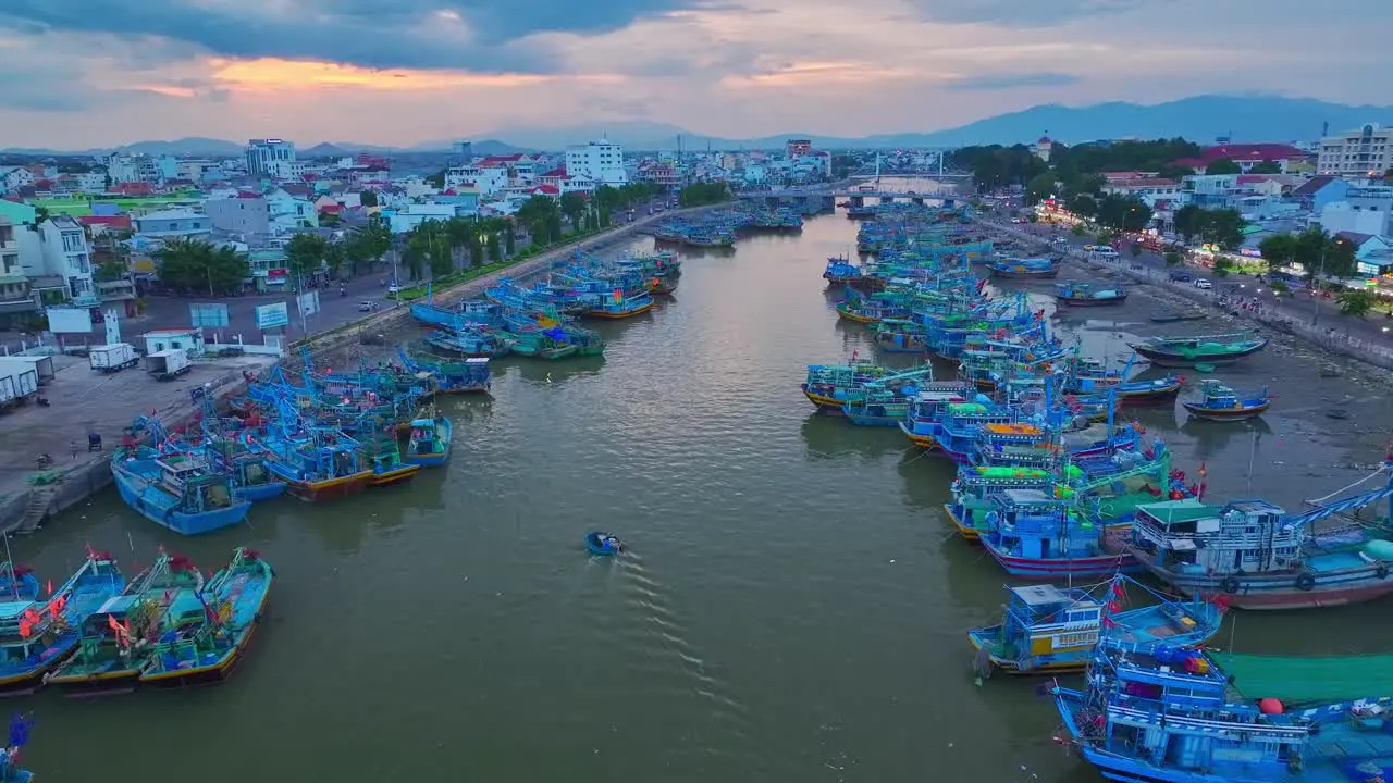 Drone view basket boat moving through fishing boats are nailing side by side on the Ca Ty river Phan Thiet city Binh Thuan province central Vietnam