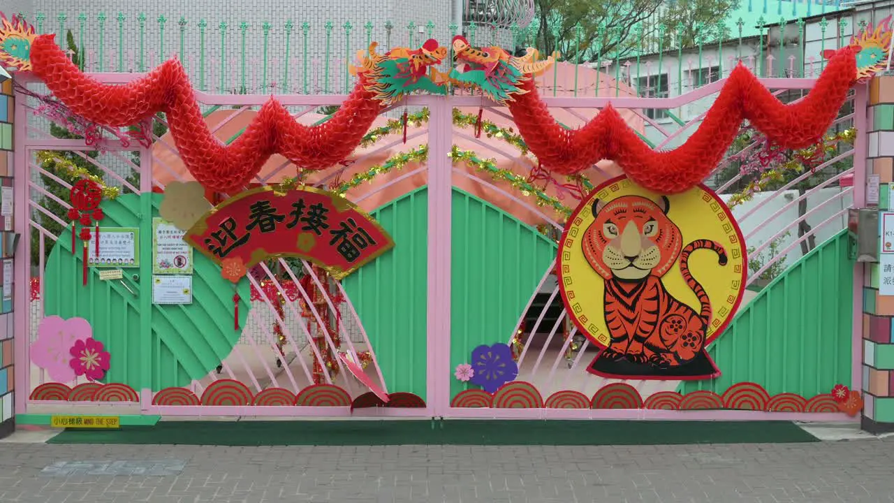 A family walks past a kindergarten school decorated with Chinese New Year ornaments ahead of the upcoming Lunar Chinese New Year in Hong Kong